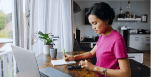 Nữ sinh viên đang tính toán ngân sách cho chi phí du học châu Âu với máy tính và sổ tay.