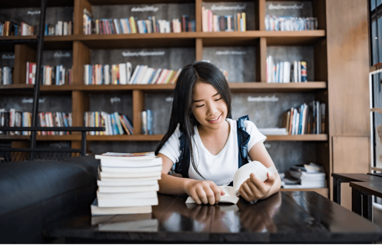 Nữ sinh viên đọc sách trong thư viện, chuẩn bị hồ sơ học bổng du học ngành tâm lý học