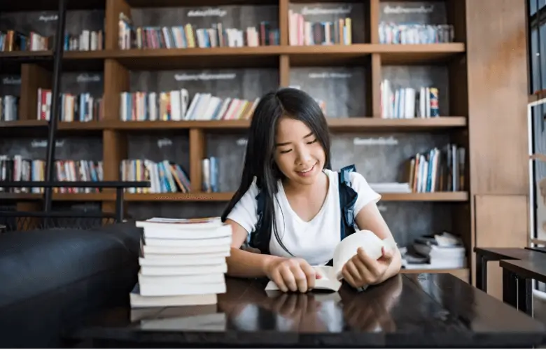 Nữ sinh viên đọc sách trong thư viện, chuẩn bị hồ sơ học bổng tâm lý học
