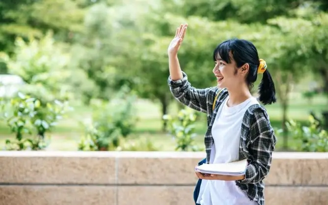 Nữ sinh viên rạng rỡ vẫy tay chào tại khuôn viên trường khi đi du học giá rẻ